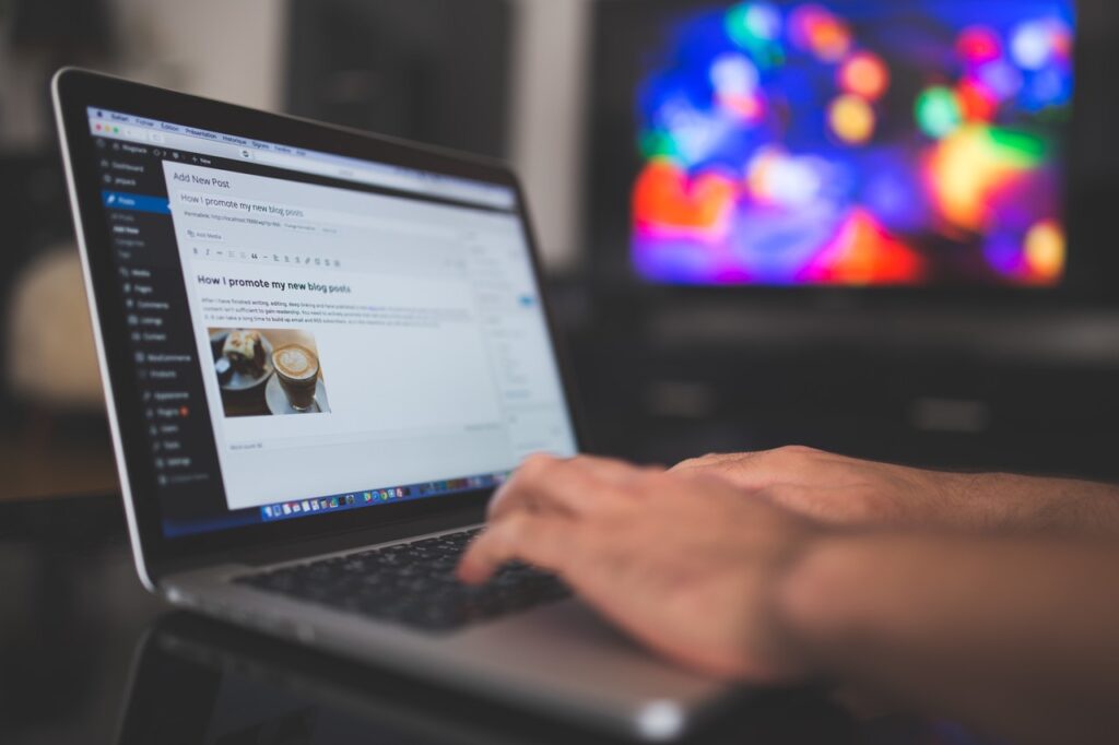 a man's hands typing on a laptop 